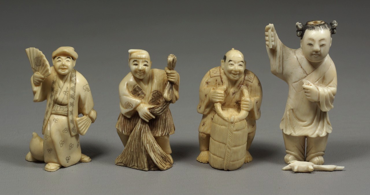 Appraisal: carved ivory Japanese netsuke figures holding various objects two signed