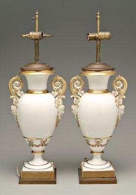 Appraisal: Pair porcelain urns scrolled handles above Bachantian heads with grapes