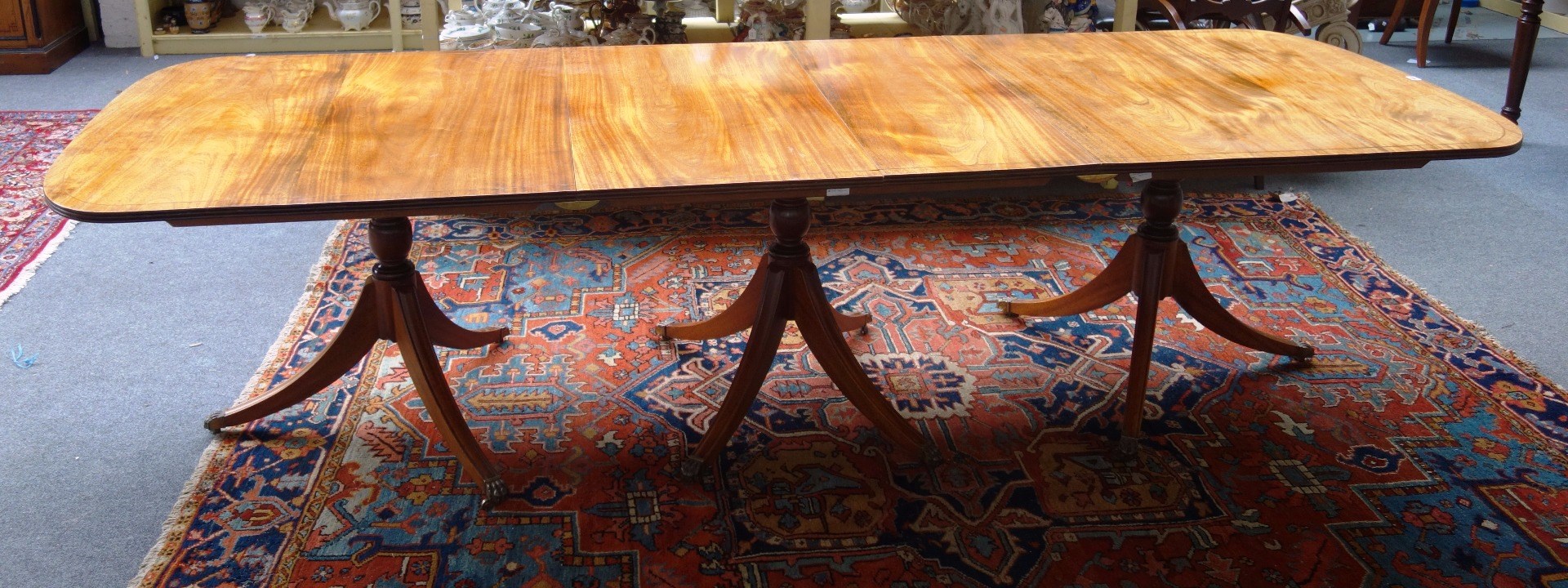 Appraisal: A Regency style mahogany triple pillar dining table on twelve