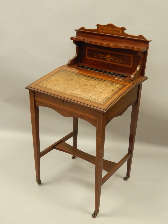 Appraisal: An Edwardian mahogany and simulated marquetry desk with a raised