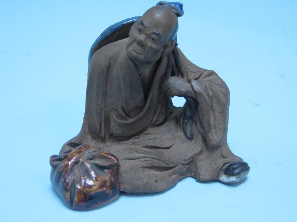 Appraisal: A Japanese pottery Figure of seated man in