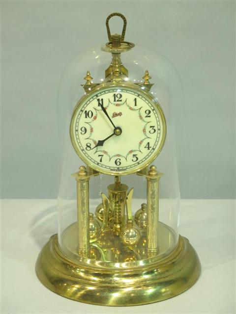 Appraisal: A SCHATZ PERPETUAL MOTION BRASS CLOCK In domed glass case