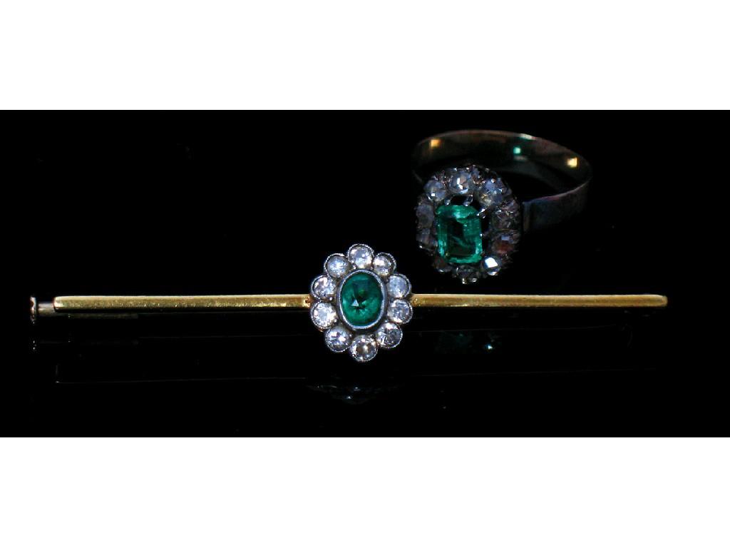 Appraisal: AN EMERALD AND DIAMOND CLUSTER BAR BROOCH the central oval