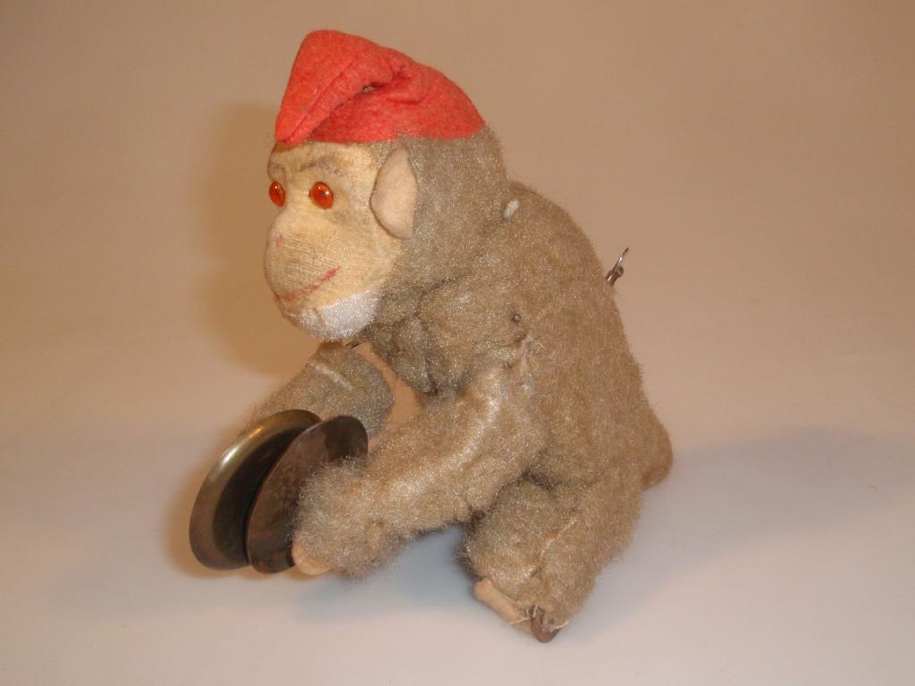 Appraisal: A 's 's clockwork monkey toy wearing a red hat