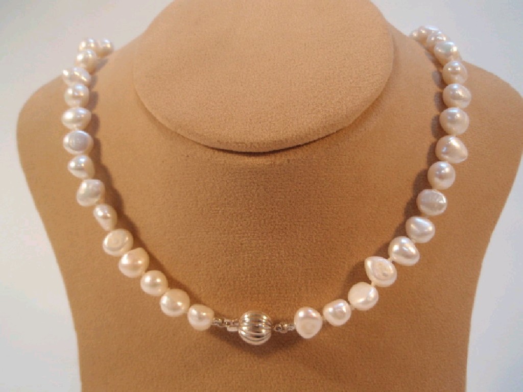 Appraisal: A string of baroque shape pearls with clasp stamped