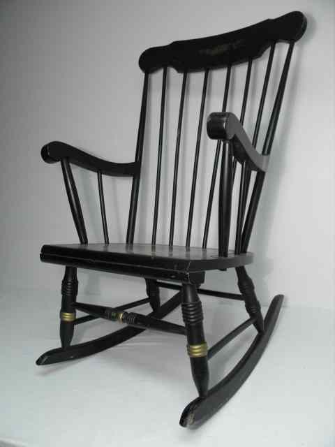 Appraisal: Black Baker style rocking chair with a gilt floral frieze