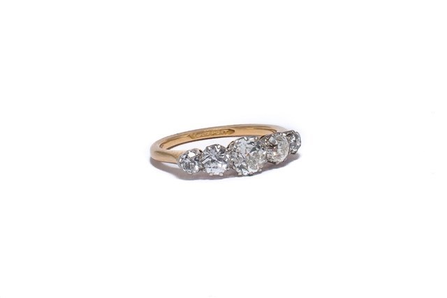 Appraisal: A gold and platinum diamond set five stone ring claw