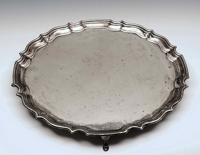 Appraisal: A SILVER SALVER with a Chippendale border and standing on