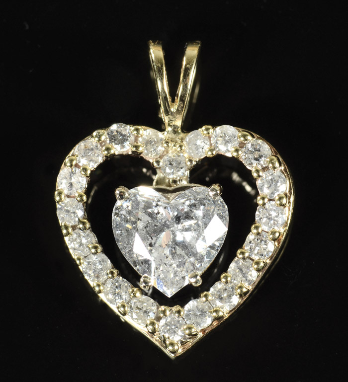 Appraisal: DIAMOND AND FOURTEEN KARAT GOLD PENDANT The open heart pendant