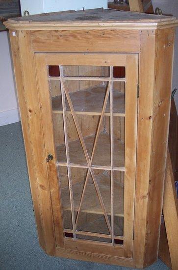 Appraisal: A pine hanging corner cupboard enclosed by a glazed bar