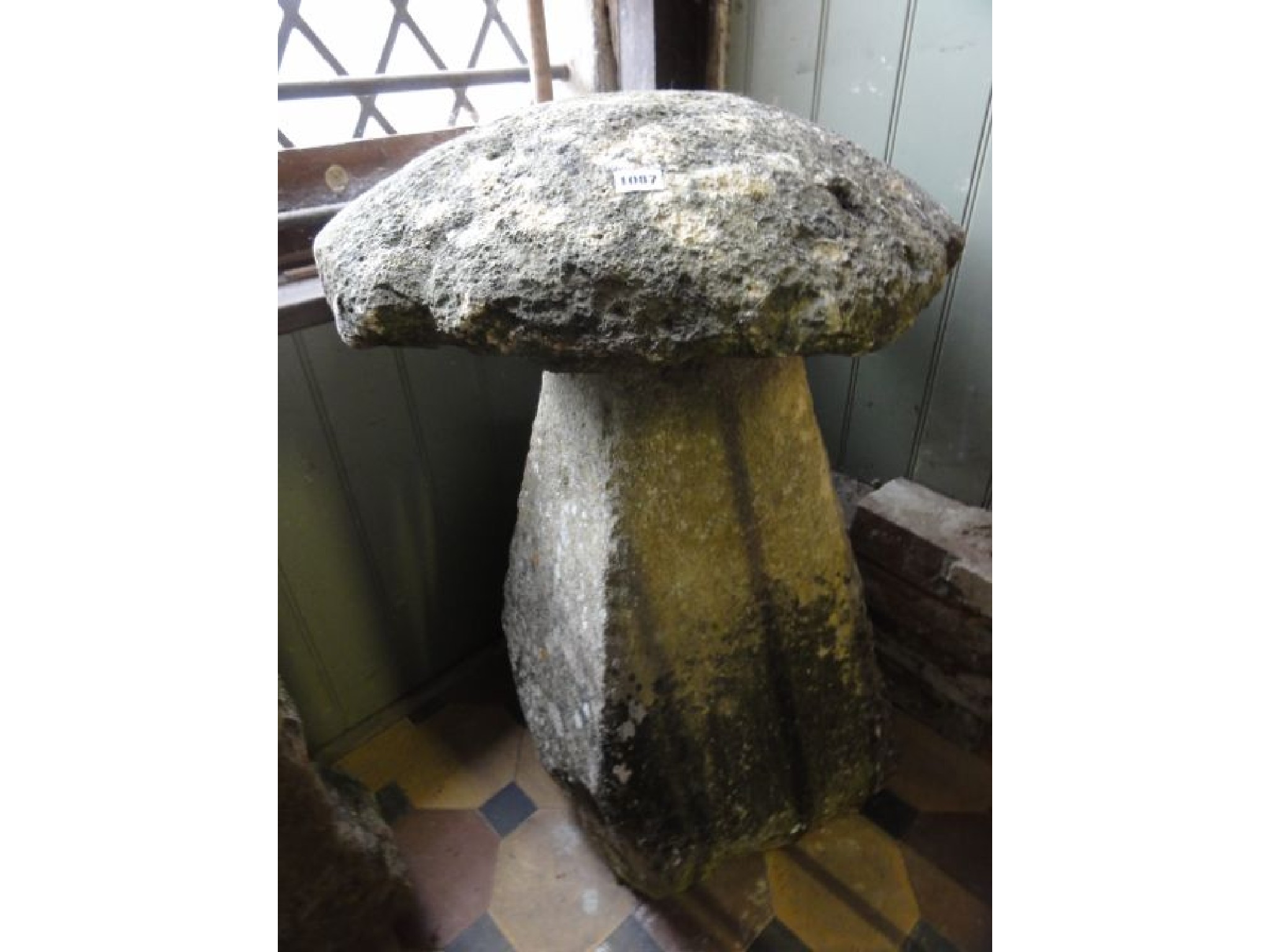 Appraisal: A weathered natural stone staddle stone and domed cap