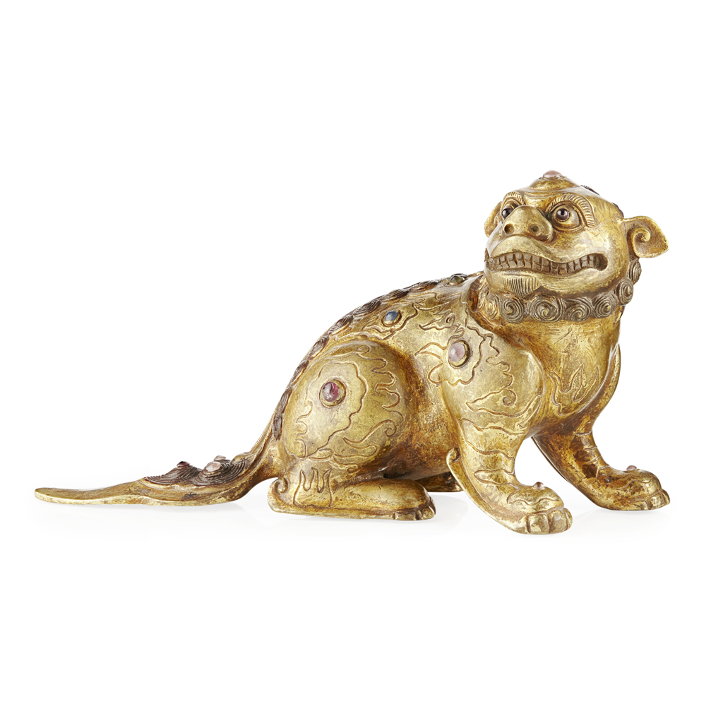 Appraisal: GILT-BRONZE BUDDHIST LION resting on hind legs with head turned