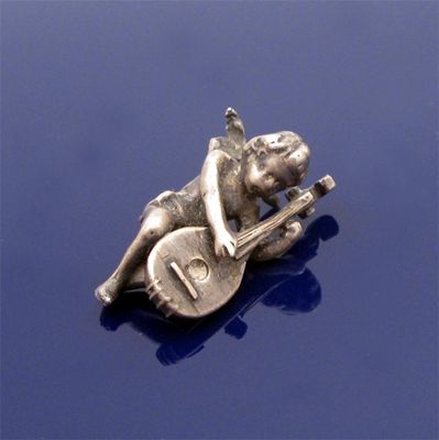 Appraisal: DIAMONDS A silver cherub charm and a gold ring set