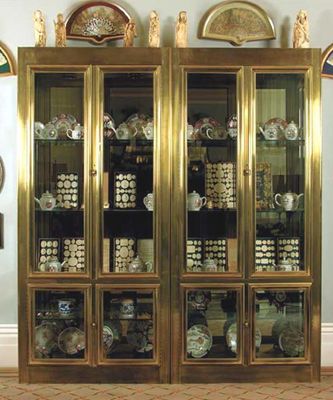 Appraisal: A pair of brass veneered display cabinets with mirrored backs