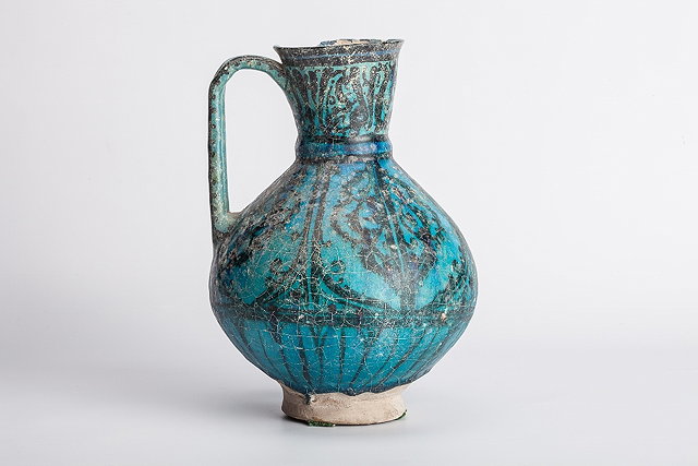 Appraisal: A PERSIAN KASHAN BLUE AND BLACK GLAZE BALUSTER EWER with