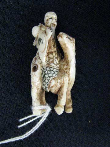 Appraisal: Carved ivory Netsuke of Man on Horseback fancy polychrome designs