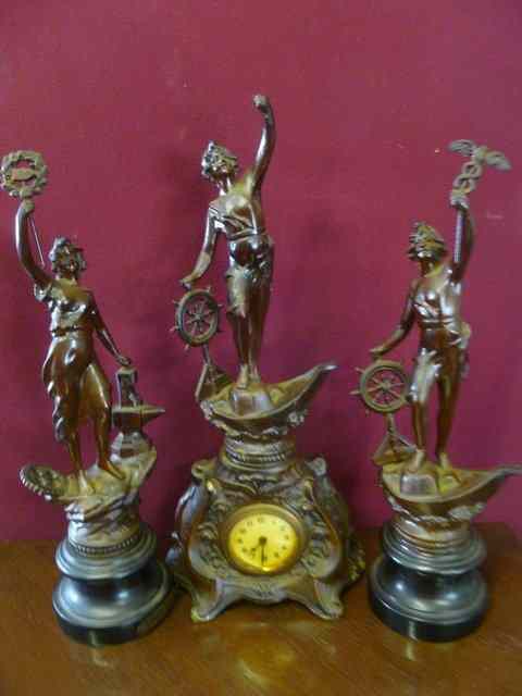 Appraisal: AN EDWARDIAN SPELTER CLOCK GARNITURE surmounted by figures with ships