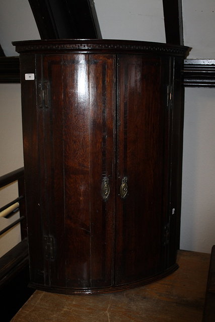 Appraisal: A GEORGIAN OAK BOW FRONT CORNER CUPBOARD with mahogany and