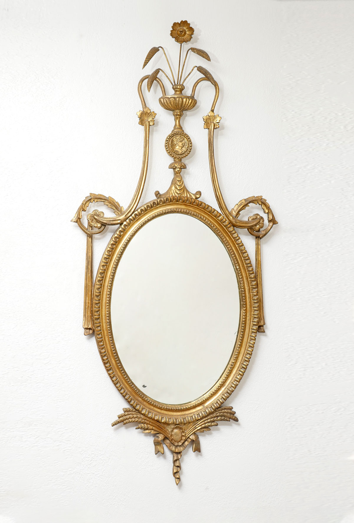 Appraisal: ITALIAN GILT CARVED MIRROR Surmounting urn with flower and foliate