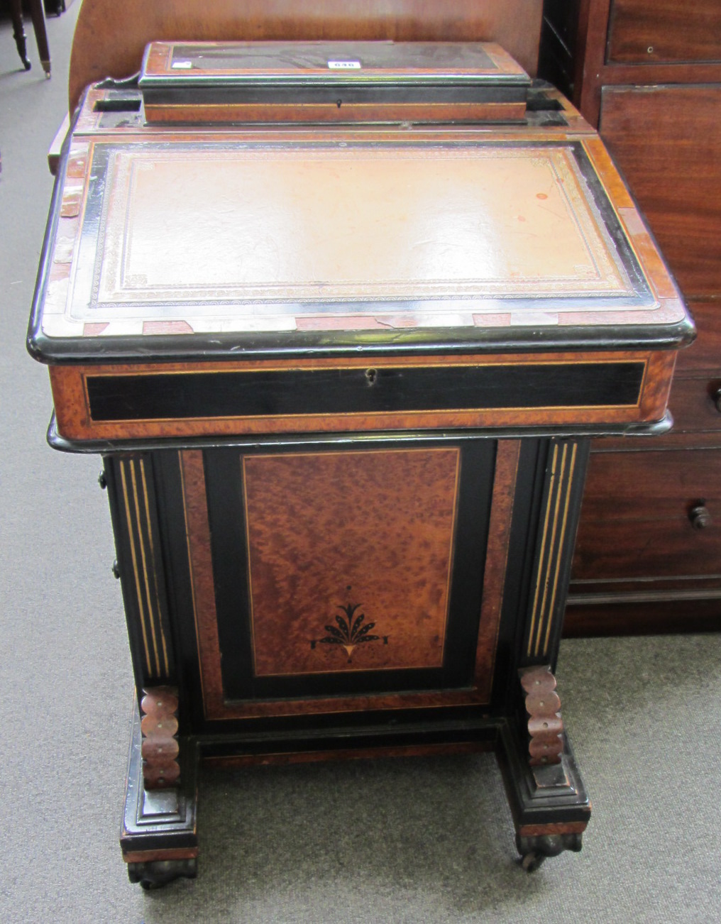 Appraisal: A Victorian ebonised amboyna banded Davenport with fitted interior over