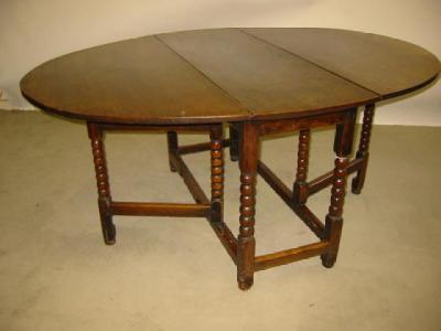 Appraisal: AN OAK GATELEG TABLE the oval plank top and plain