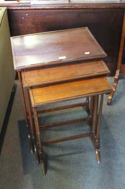 Appraisal: A NEST OF THREE EDWARDIAN MAHOGANY OCCASIONAL TABLES on gun