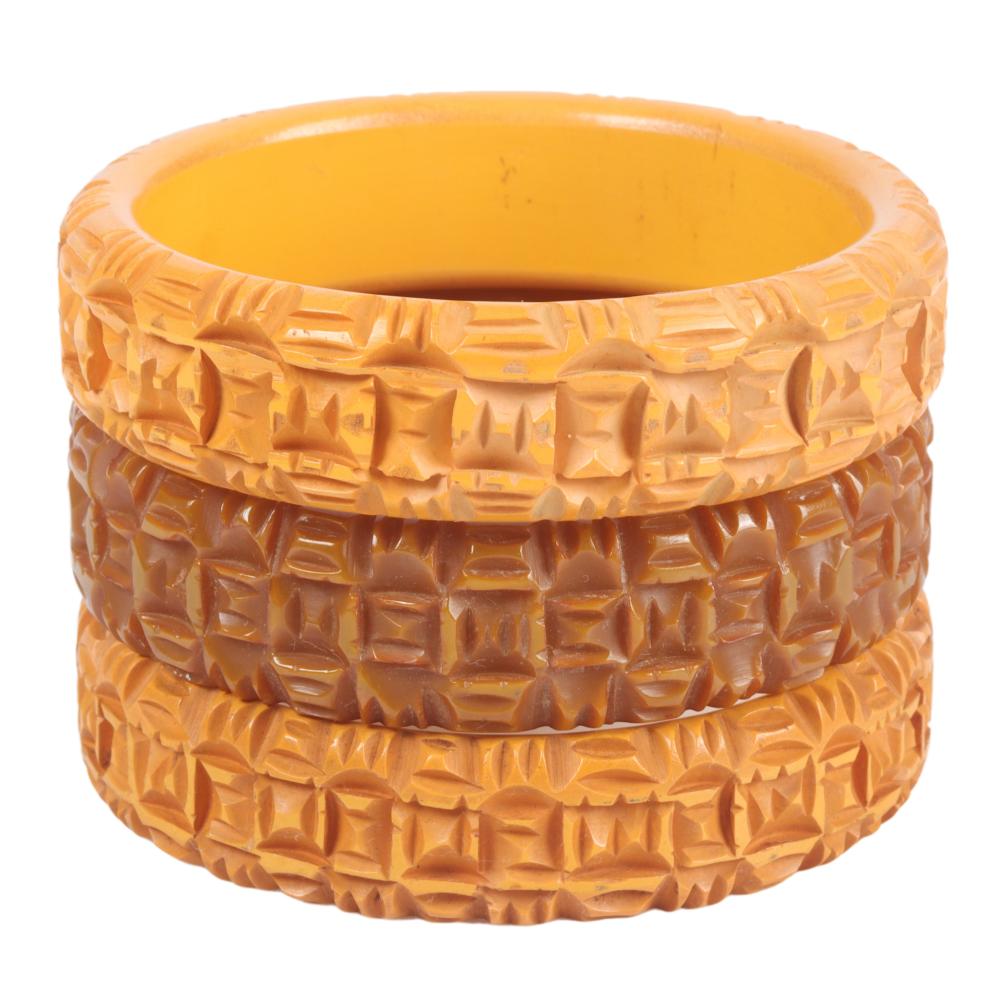 Appraisal: THREE BAKELITE BANGLE BRACELETS WITH CARVED TIKI DESIGN H X