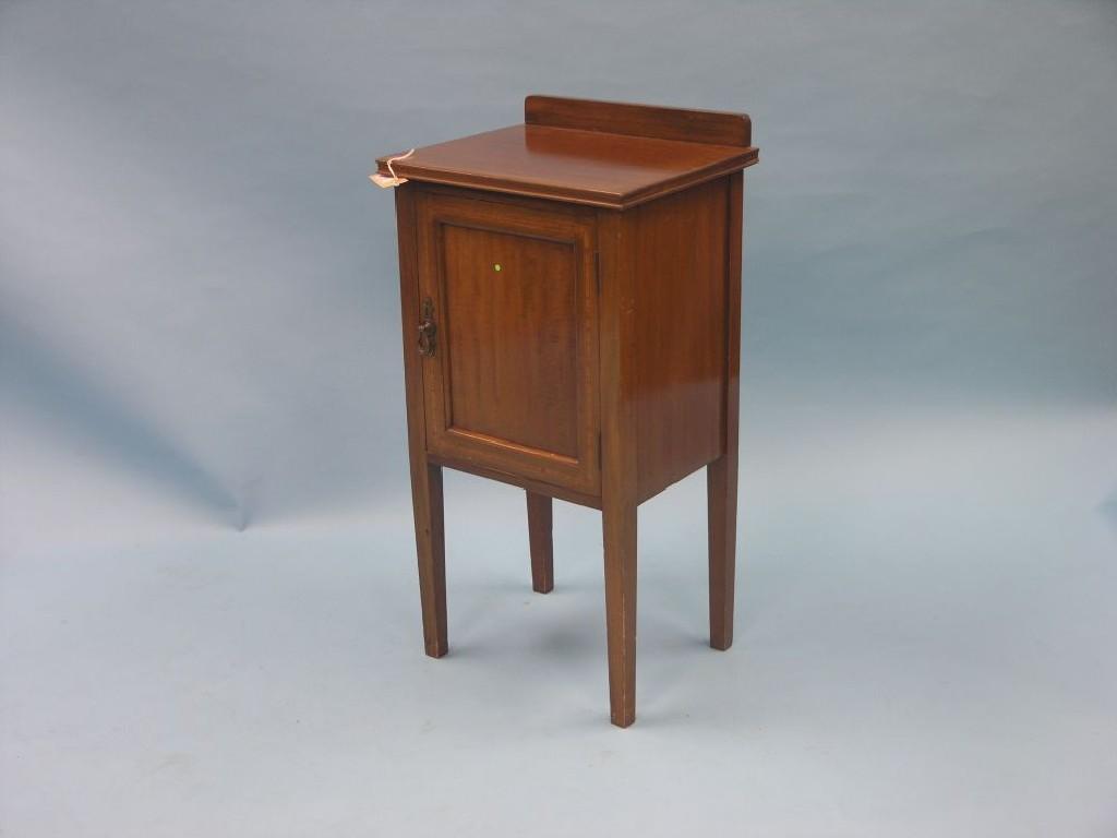 Appraisal: An Edwardian inlaid mahogany bedside cupboard enclosed by single panelled