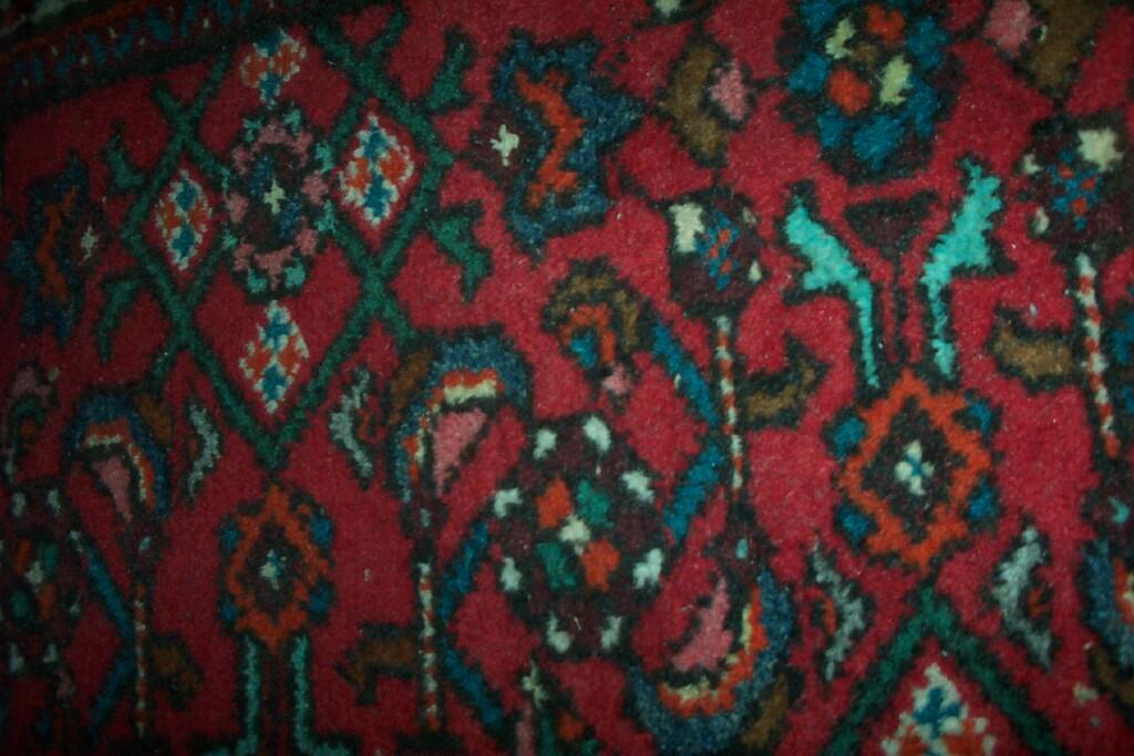 Appraisal: A red ground Eastern wool prayer rug with geometric decoration