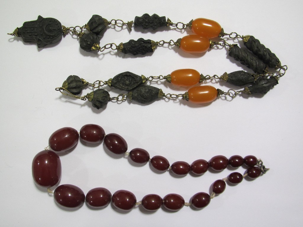 Appraisal: Lot comprising a red amber bead choker necklace needs restrung