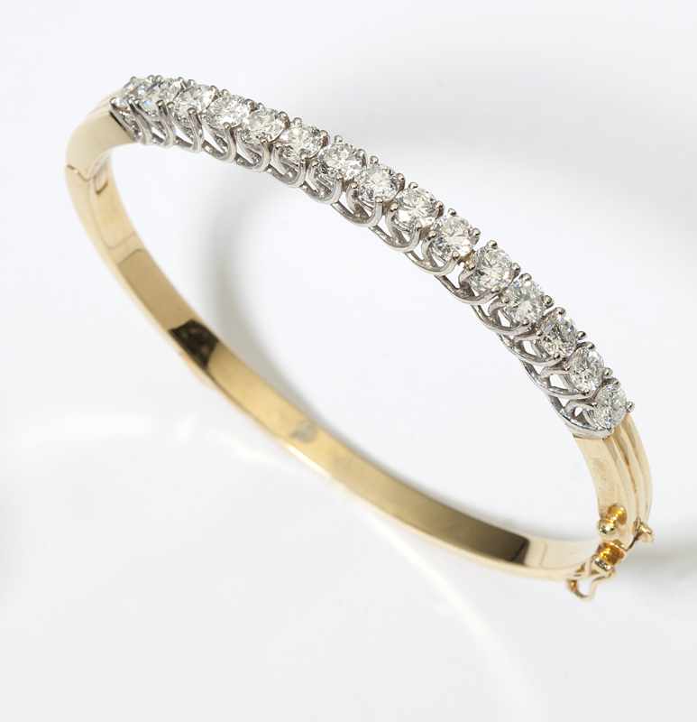 Appraisal: A diamond and gold bangle The tested K gold oval-shaped