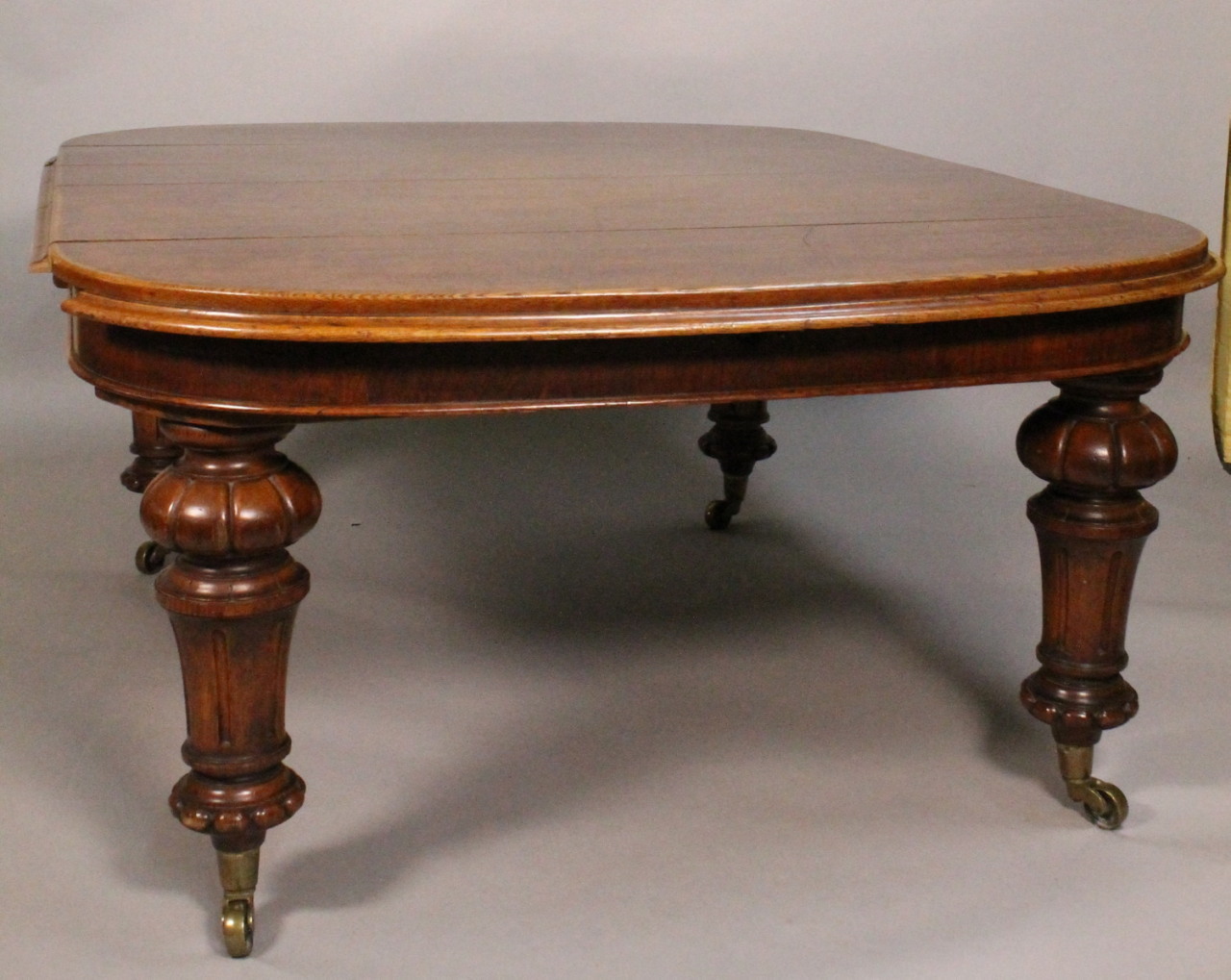 Appraisal: A Victorian oak extending dining table the top with rounded