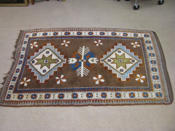 Appraisal: Wool hand woven area rug with geometric design Brown background