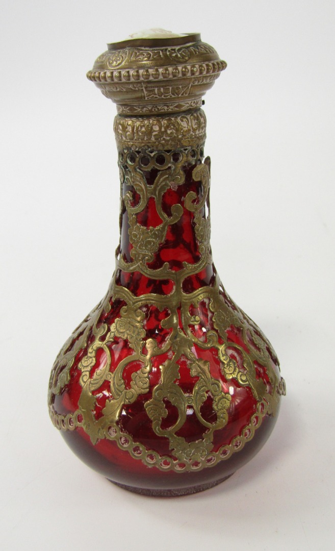 Appraisal: A Continental ruby glass scent bottle with pierced foliate brass