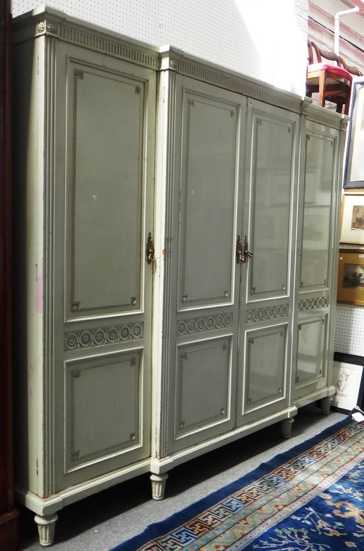 Appraisal: A large cream painted breakfront four section wardrobe on fluted