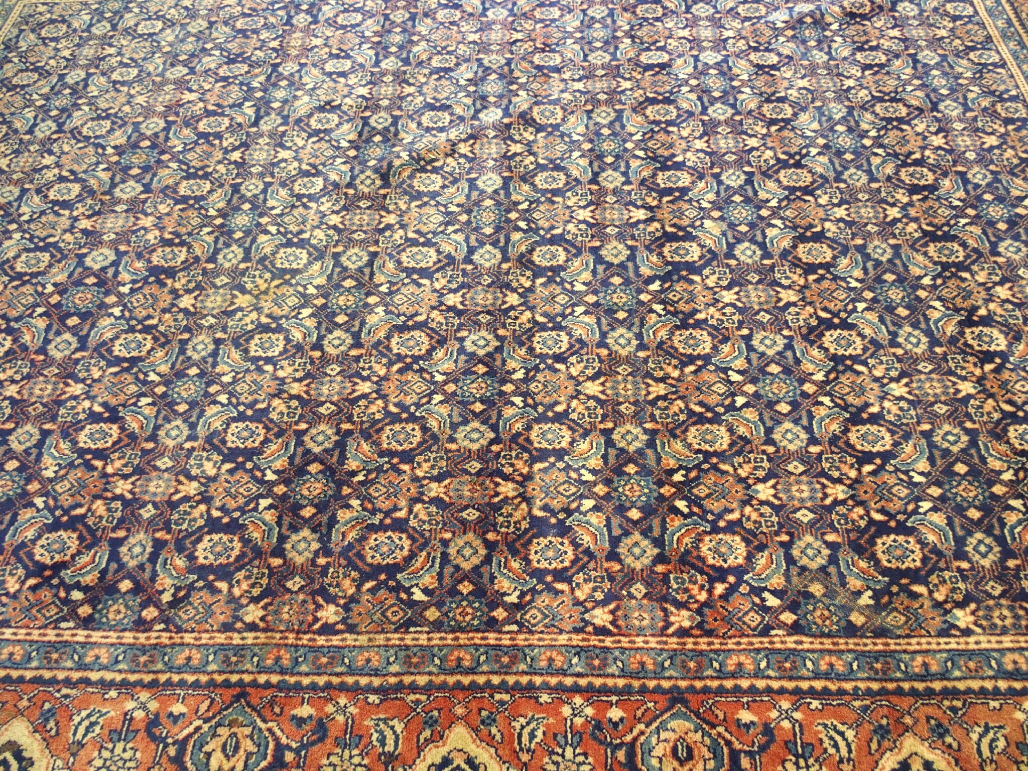 Appraisal: A Persian blue ground carpetwith repetitive foliate bands within a