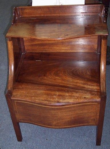 Appraisal: A George III mahogany serpentine fronted commode with hinged flap