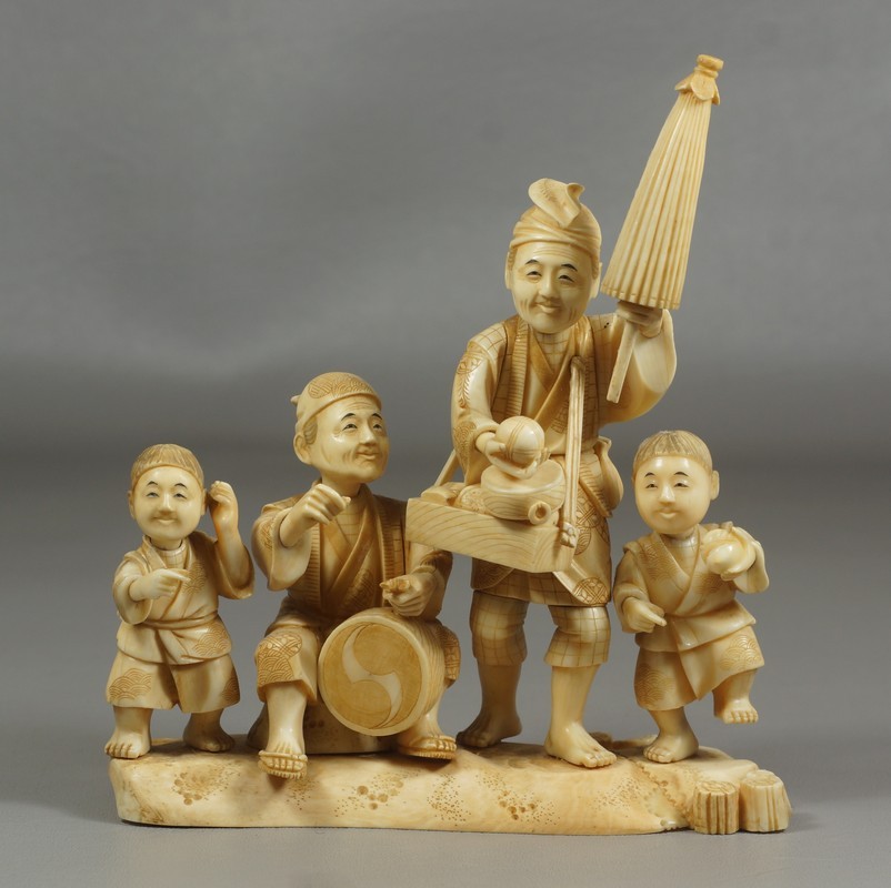 Appraisal: Japanese carved ivory grouping of vendor with umbrella boy with