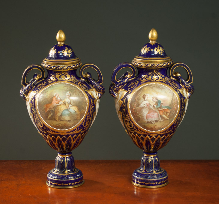 Appraisal: TWO FRENCH SEVRES PORCELAIN COVERED URNS hand painted with royal