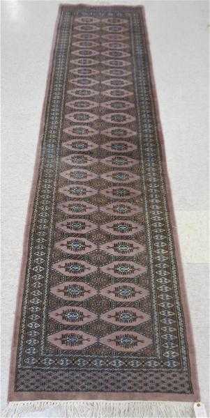 Appraisal: HAND KNOTTED BOKHARA RUNNER repeating Turkoman gol design on mauve