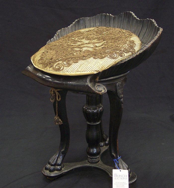 Appraisal: Ebonized carved Continental piano stool with shelf form seat some