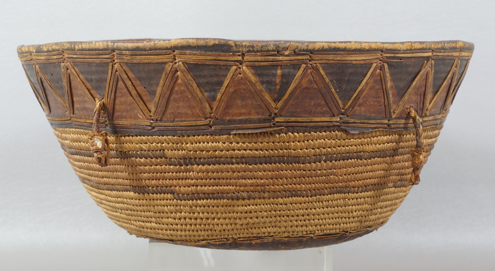 Appraisal: Tribal woven basket with leather accent dia