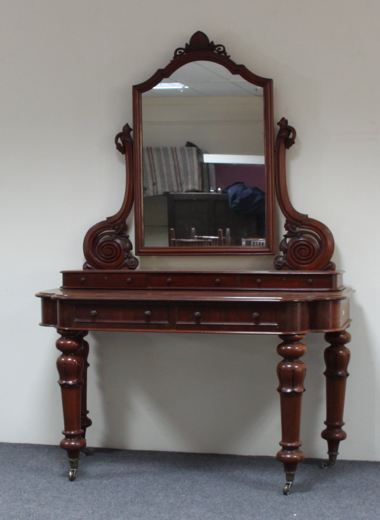 Appraisal: An early Victorian mahogany dressing table the arched mirror on