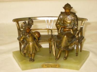 Appraisal: AN ART DECO BRONZE GROUP modelled as a lady sitting