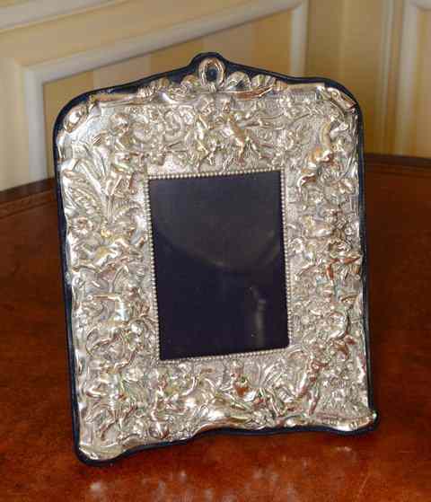 Appraisal: A VICTORIAN STYLE PHOTO FRAME decorated with cherubs in relief