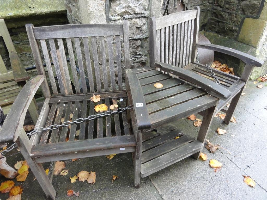 Appraisal: A weathered hardwood garden twin seat with slatted panels and