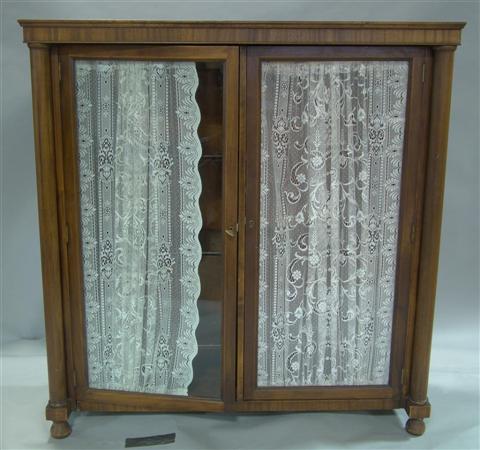 Appraisal: EMPIRE MAHOGANY BOOKSHELF rectangular cornice over two hinged glass doors