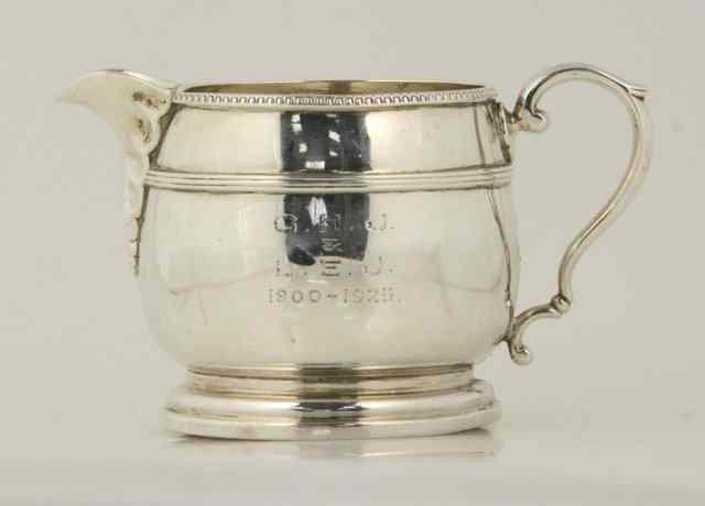 Appraisal: A silver cream jug Birmingham of circular form engraved from