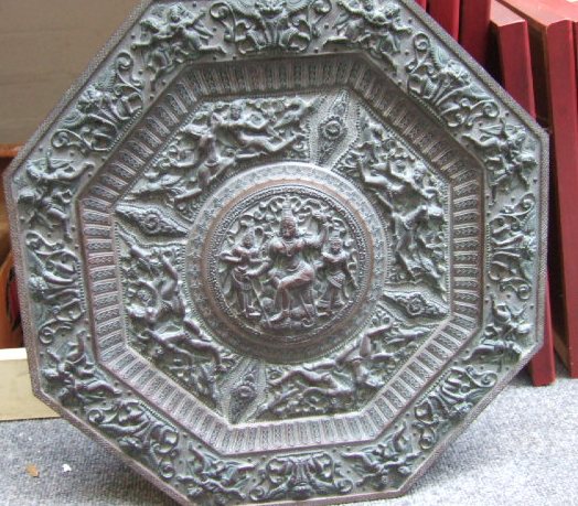 Appraisal: An octagonal brass relief panel showing Hindu gods in a