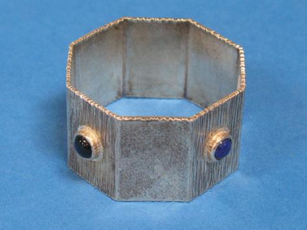 Appraisal: MICHAEL BOLTON A NAPKIN RING of octagonal form with textured